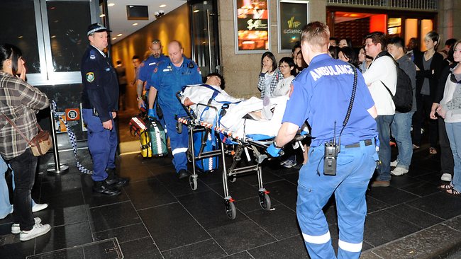 Paramedics tend to a man injured in a stampede after sniffer dogs enter The Ivy