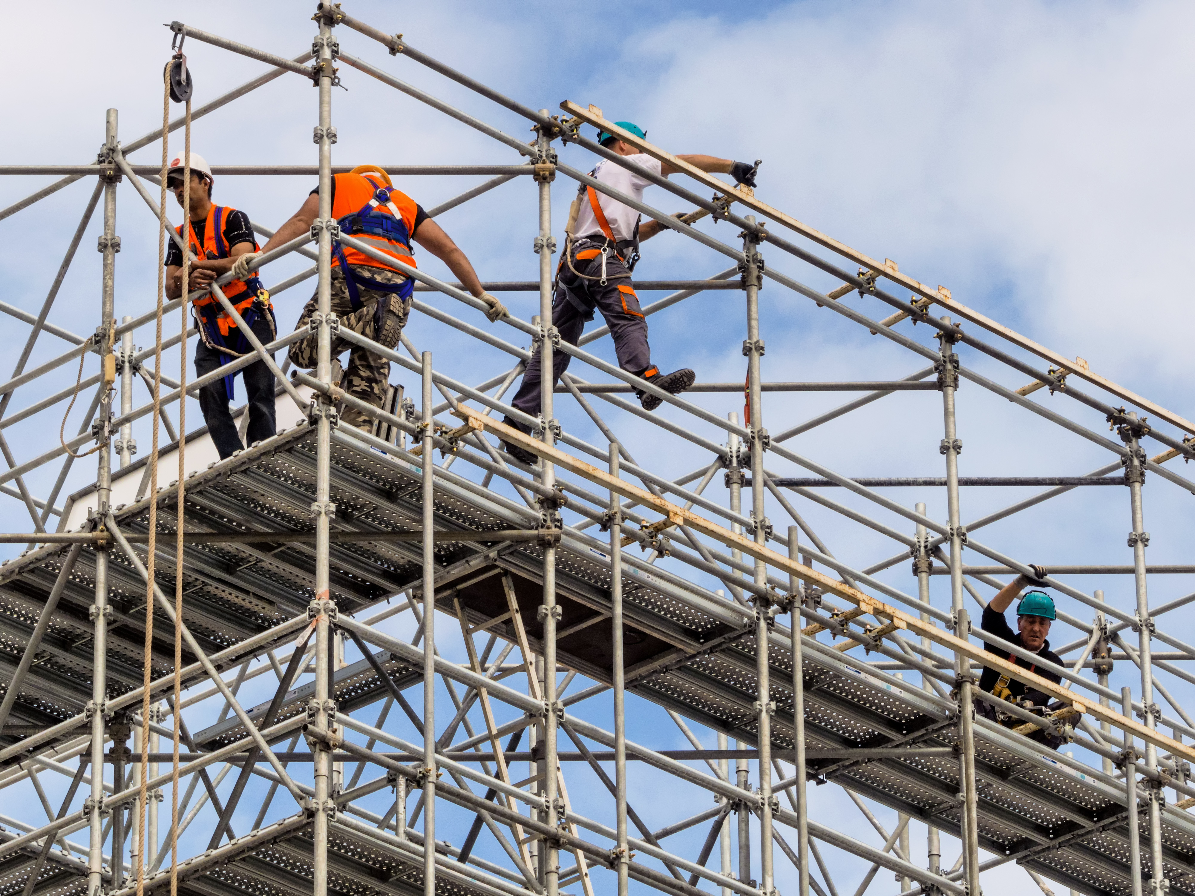 Three Pacific Islander-Australians scaffolding on the top of a Brisbane skyscraper.